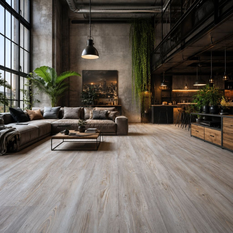 Offenes Loft-Wohnzimmer mit Kronotex Robusto Fantasy Wood Laminat in graubrauner Holzoptik, modernes Design mit grauem Sofa, industriellen Pendelleuchten, Betonwänden und hängenden Pflanzen - Floor4all