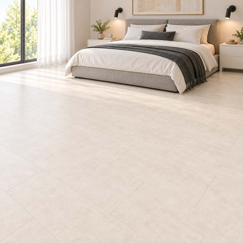 Laminat Klick Fliesenoptik Visiogrande Sichtestrich Weiß im Schlafzimmer mit grauem Polsterbett und natürlichem Tageslicht – Restposten bei Floor4All.