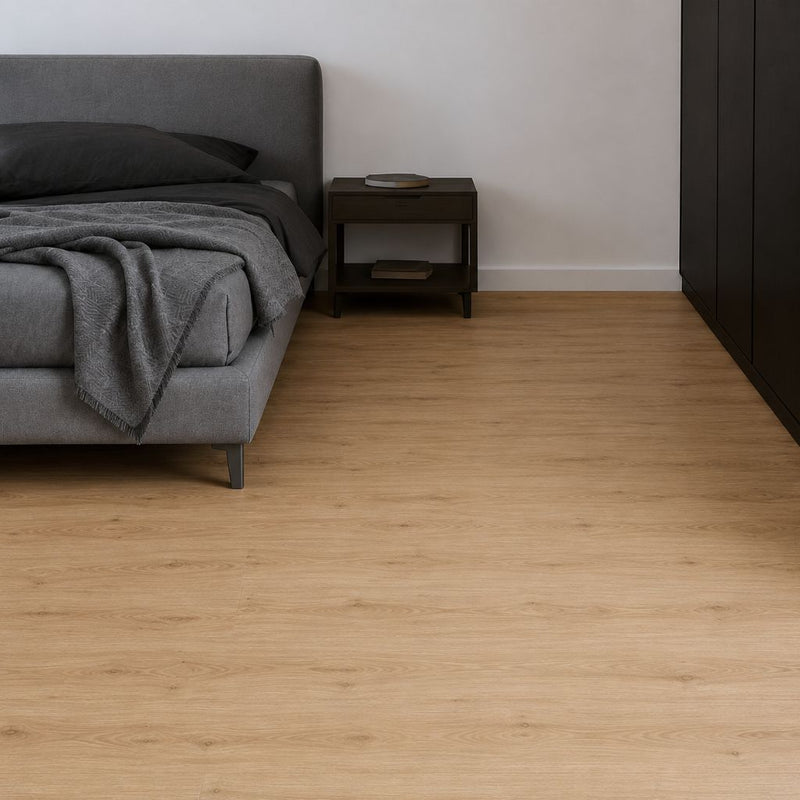 Gemütliches Schlafzimmer mit hellem Vinylboden neben grauem Bett – warmes Laufgefühl durch integrierte Trittschalldämmung. Sunrise Edge GT von Floor4all
