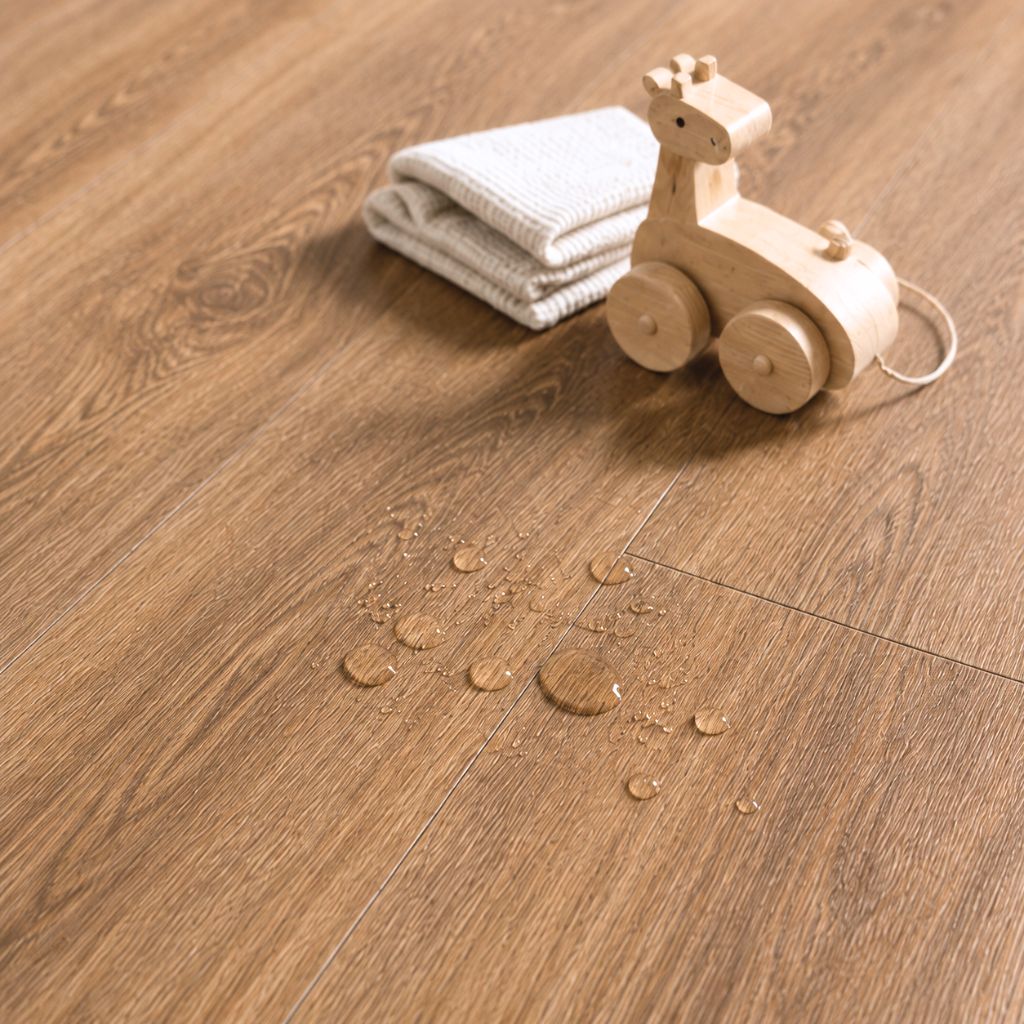 Wassertropfen auf dem Nussbaum-Vinylboden zeigen die feuchtigkeitsunempfindliche Oberfläche von Floor4all